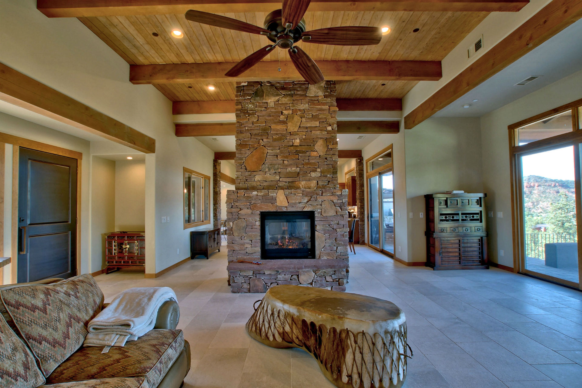 A living room with a fireplace and wooden beams.
