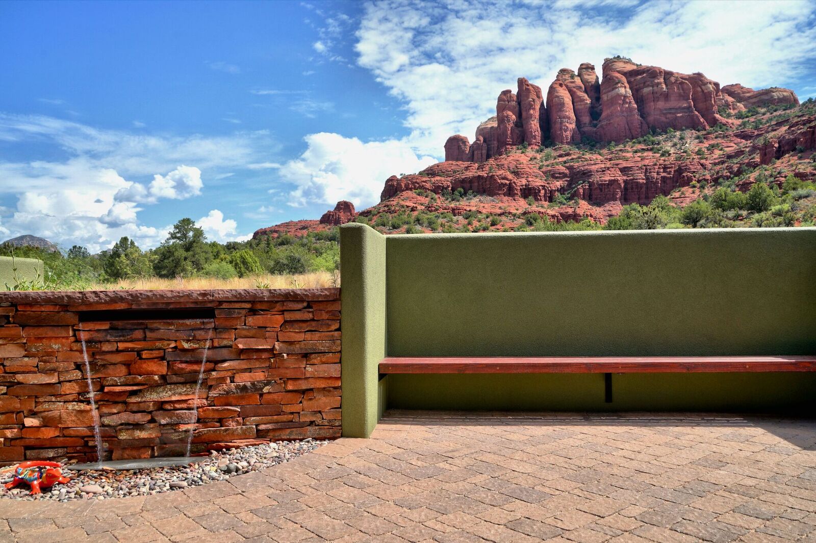 A bench sitting in front of a rock wall.