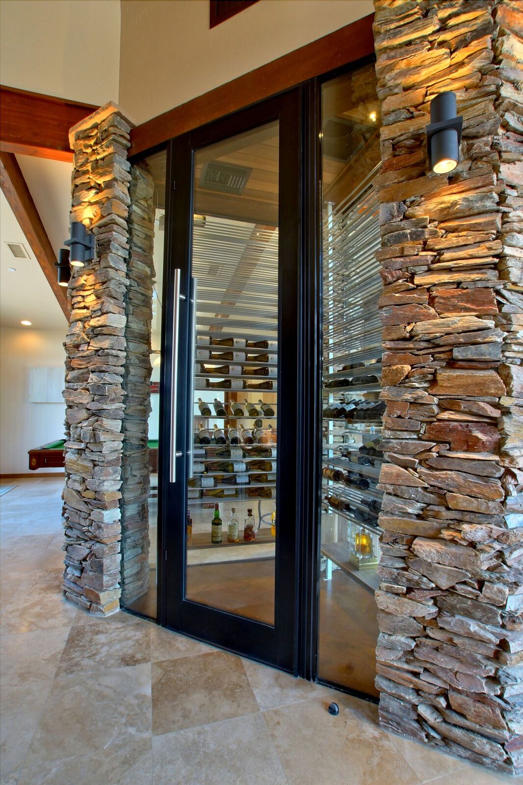 A glass door with a stone wall in the background.