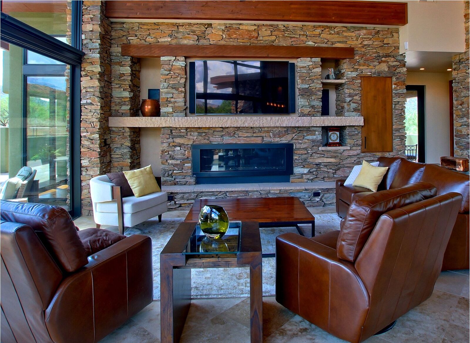 A living room with leather furniture and a fireplace.