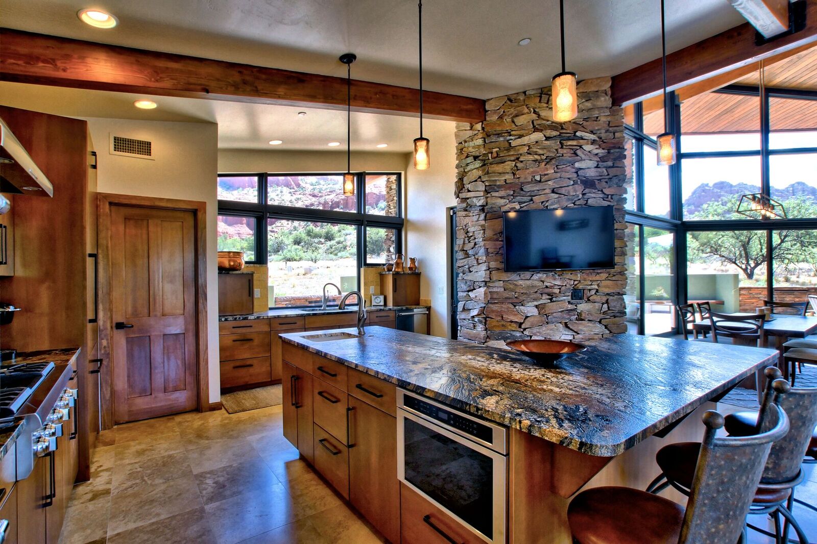 A kitchen with stone walls and a large window.
