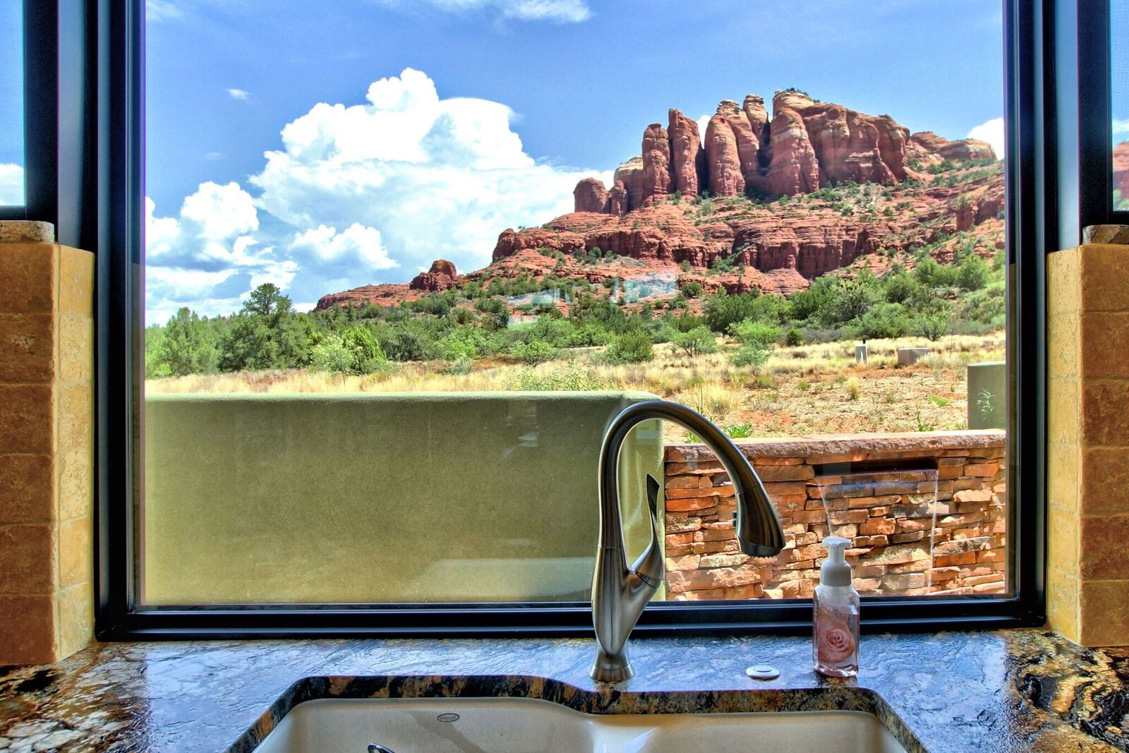 A sink with a view of the mountains in the background.