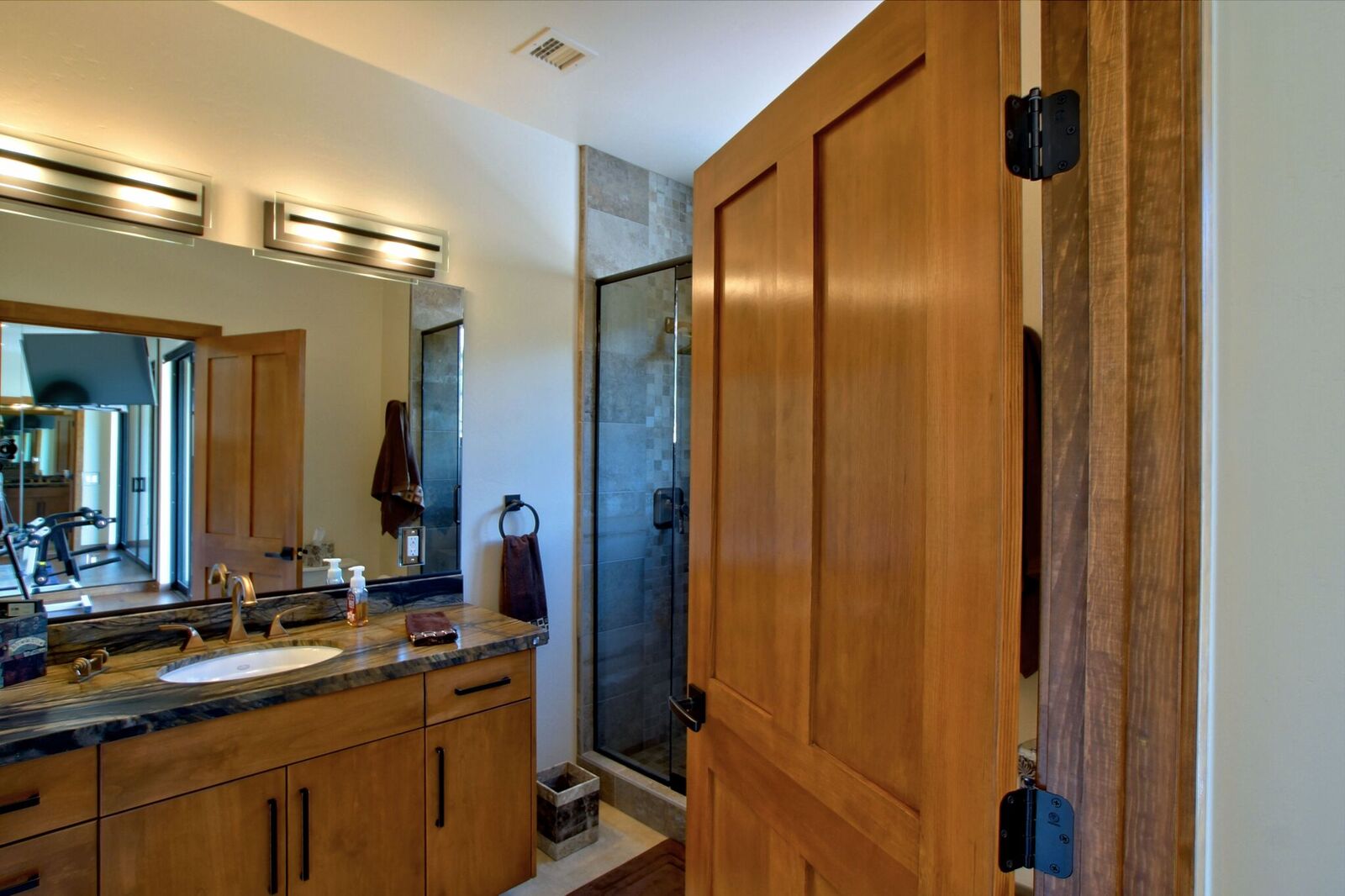 A bathroom with wooden cabinets and a large shower.