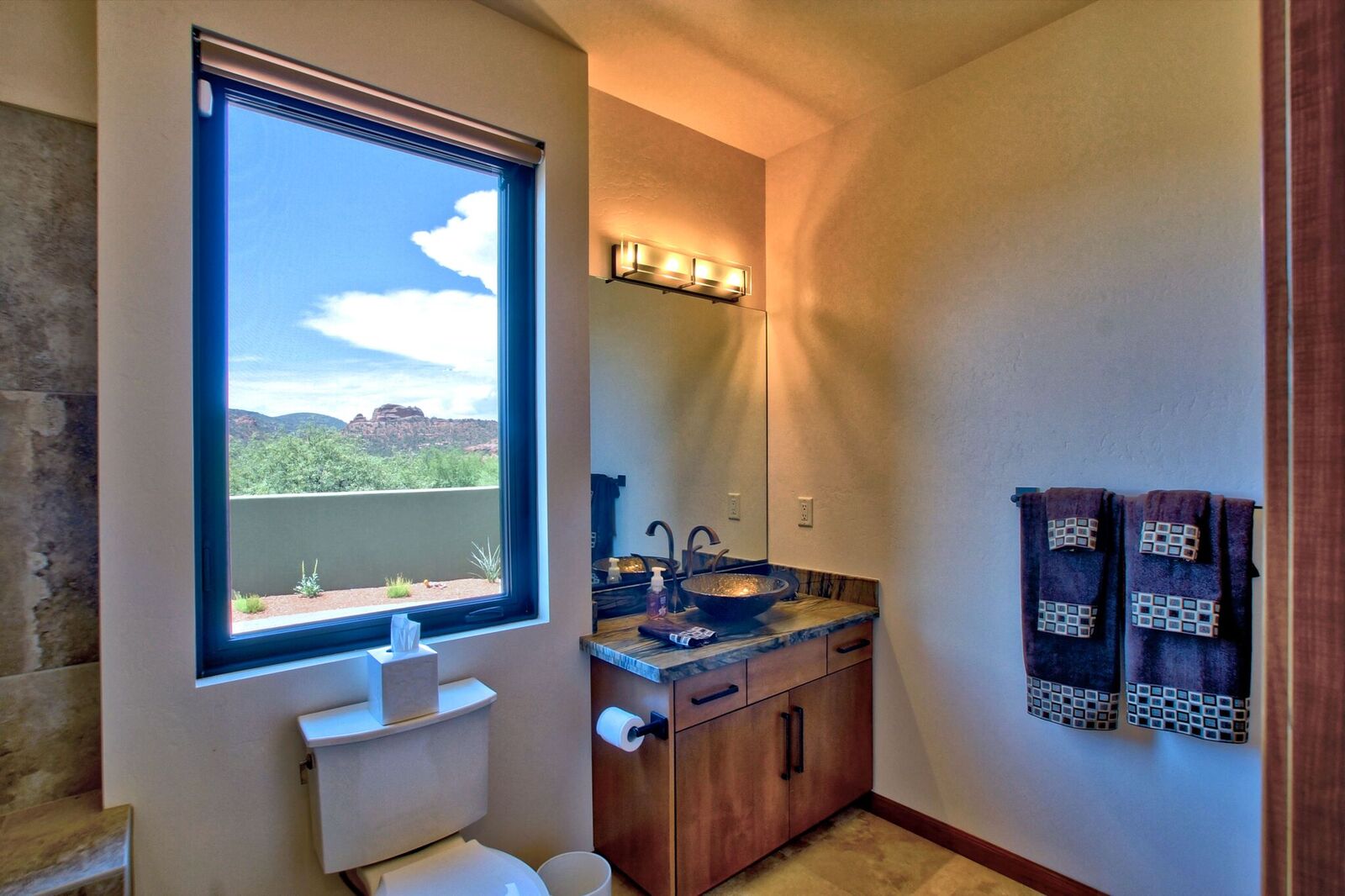 A bathroom with a large window and a view of the mountains.