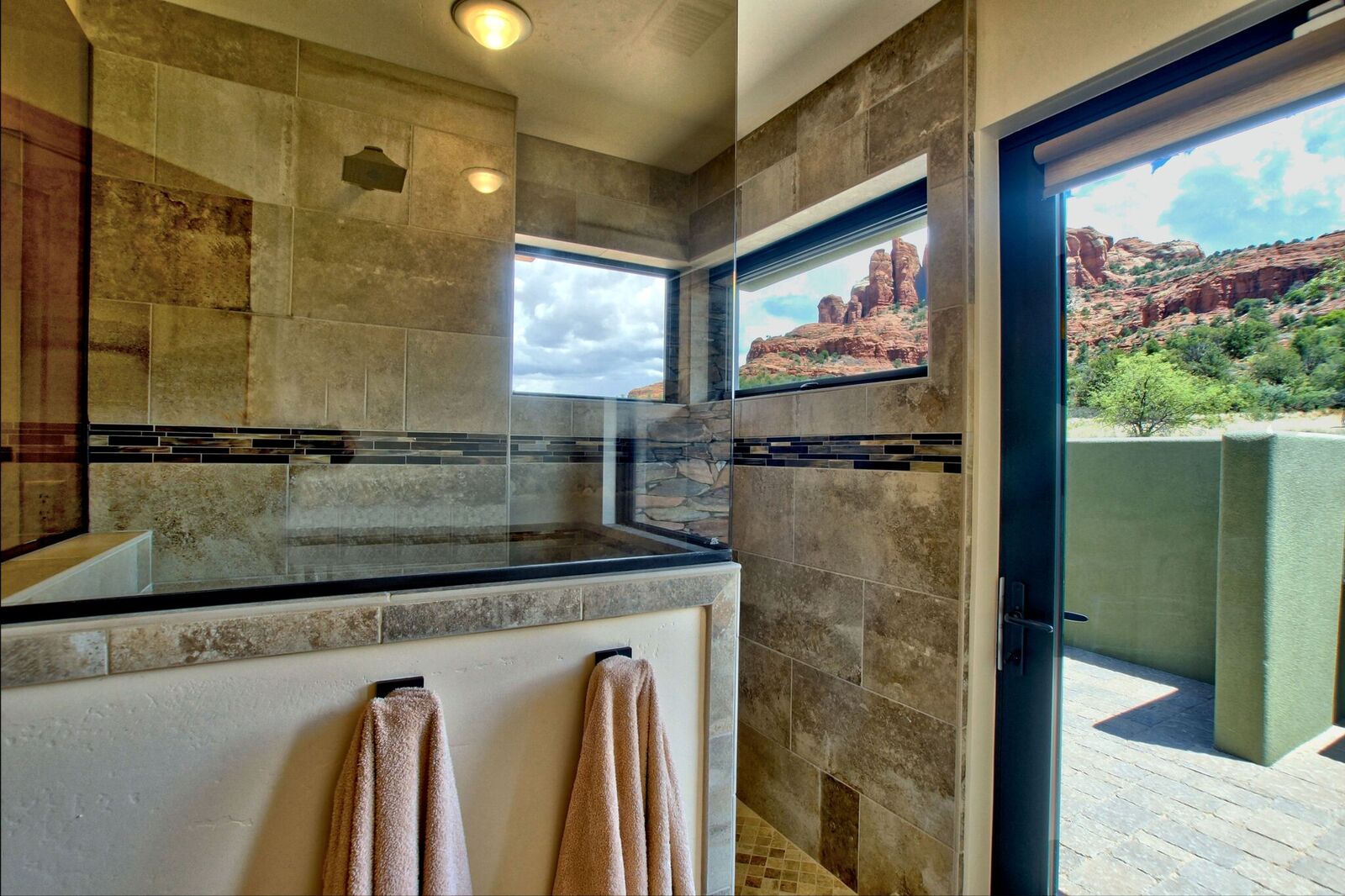 A bathroom with a large shower and a window.